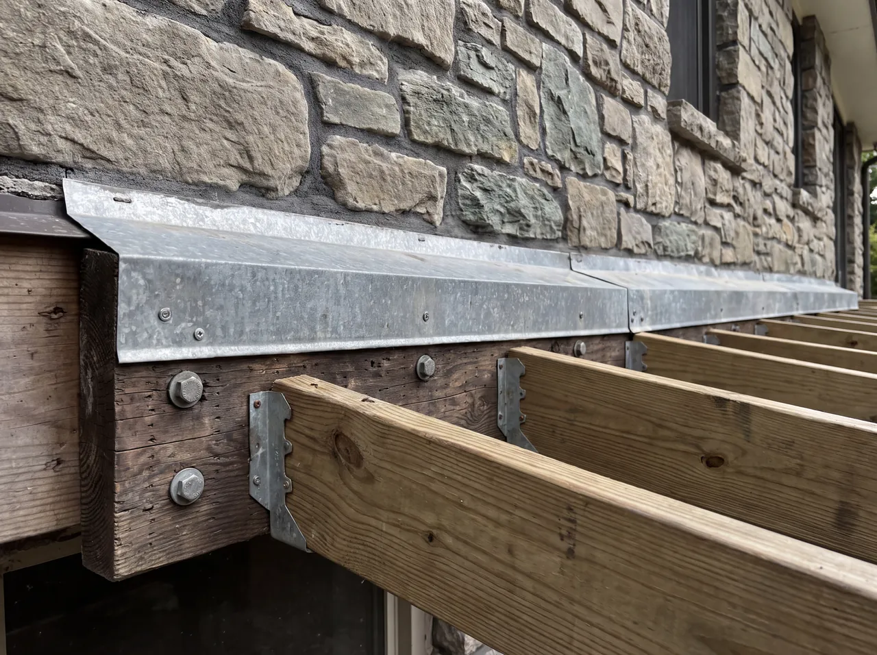 A flashed deck ledger board bolted to the house